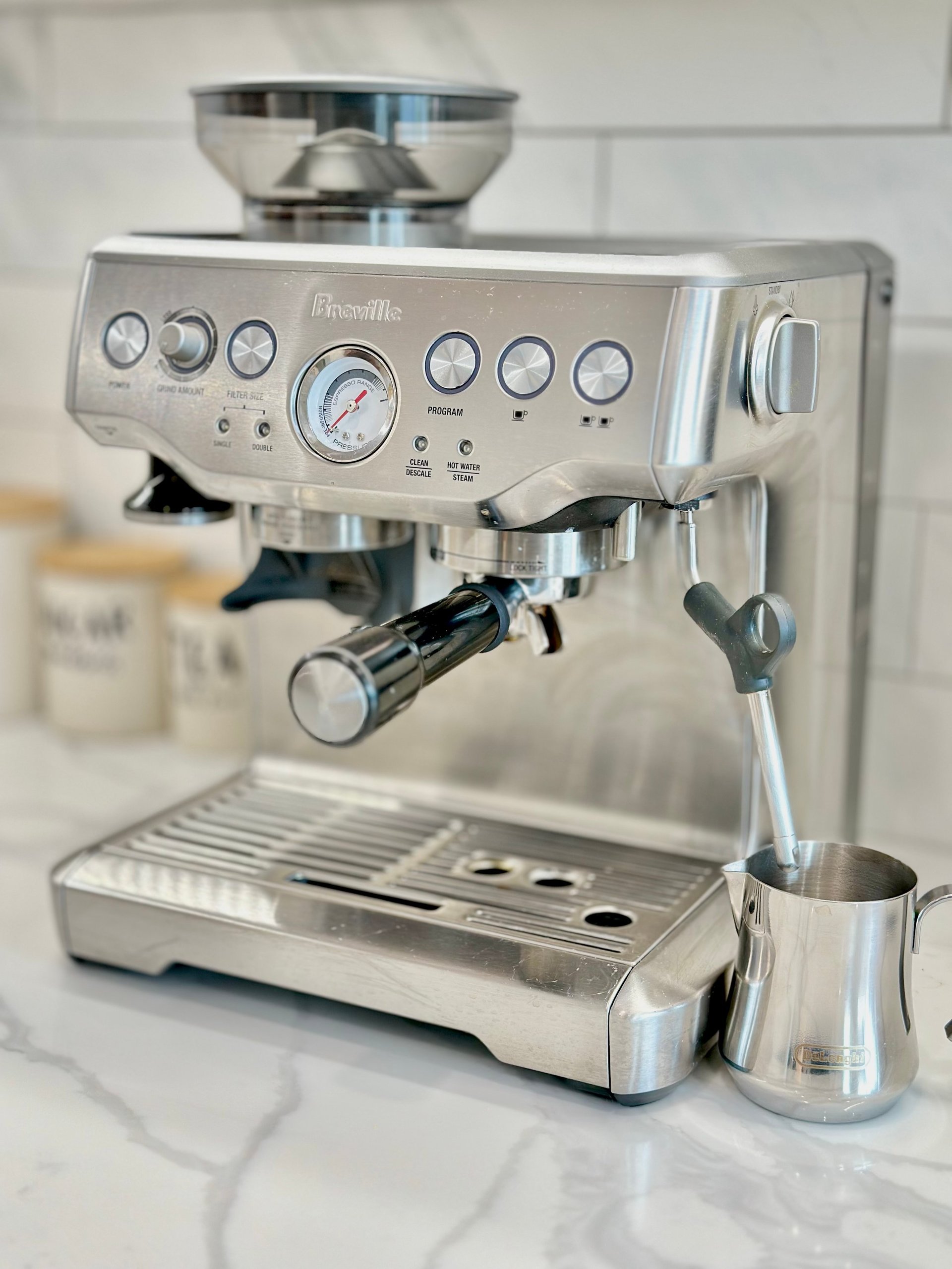 Breville stainless steel espresso machine with grinder on marble countertop